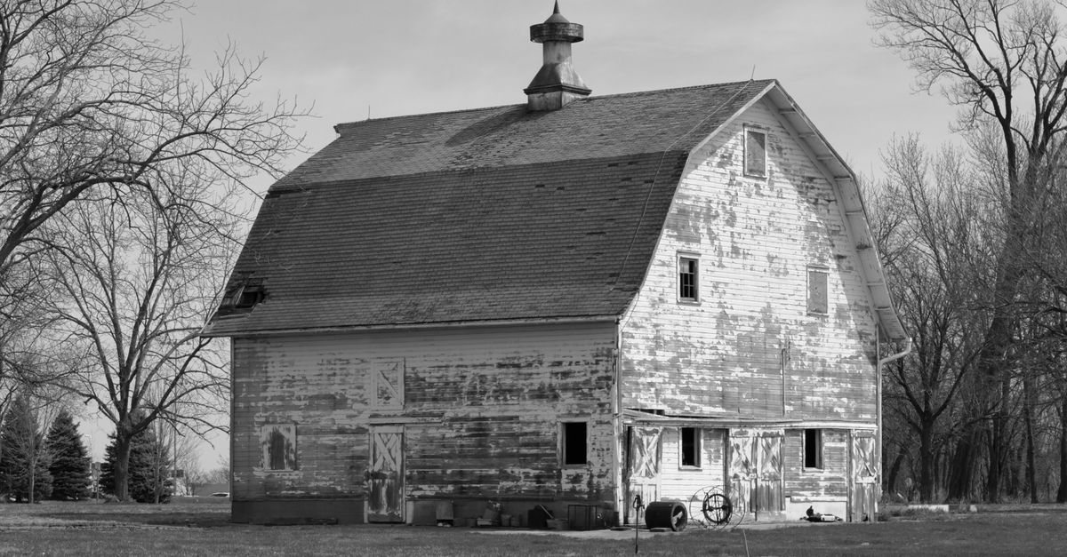 Black and white photo of a rustic, weathered barn in Oskaloosa, Iowa.